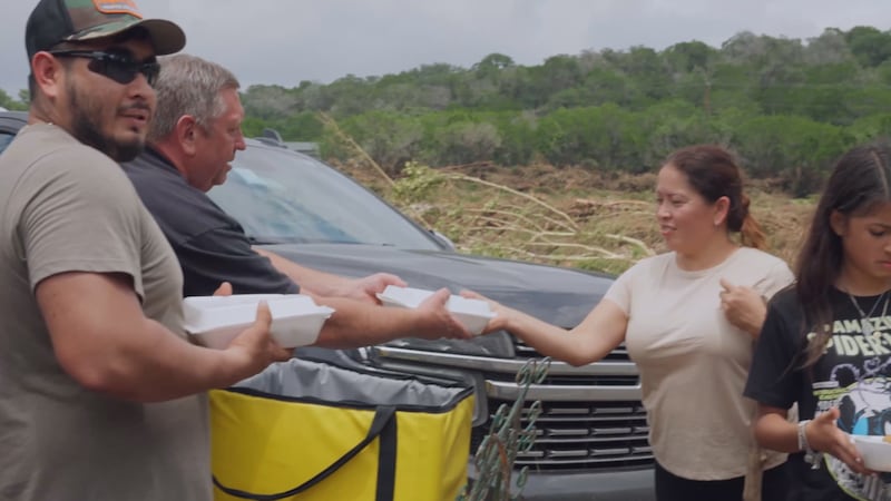 Volunteers from Mercy Chefs hand out meals to first responders, families, and flood victims in...