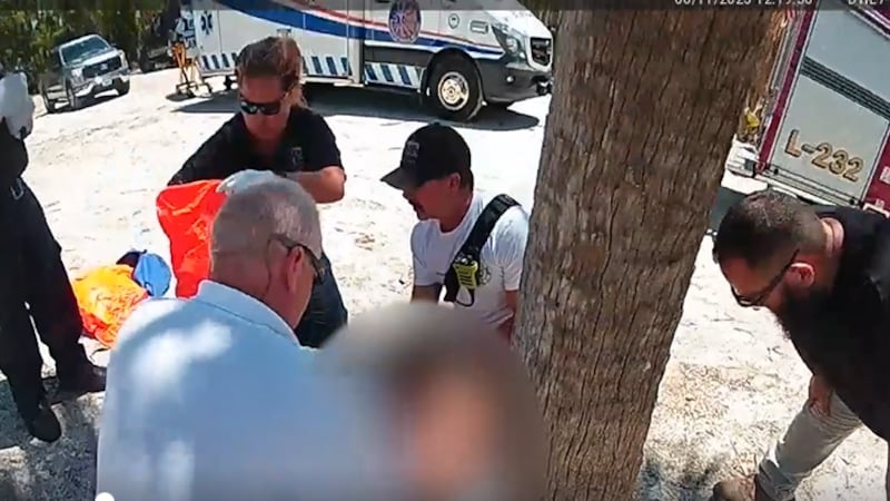 Paramedics tend to 9-year-old Leah Lendel, after she was bitten by an 8-foot shark off Boca...