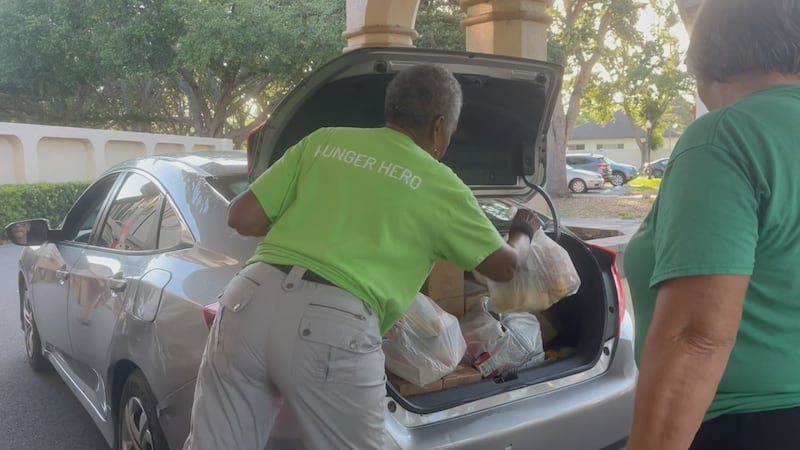 Senior Friendship Center volunteer, Barbara Willis, loads food into a Venice residents' car on...