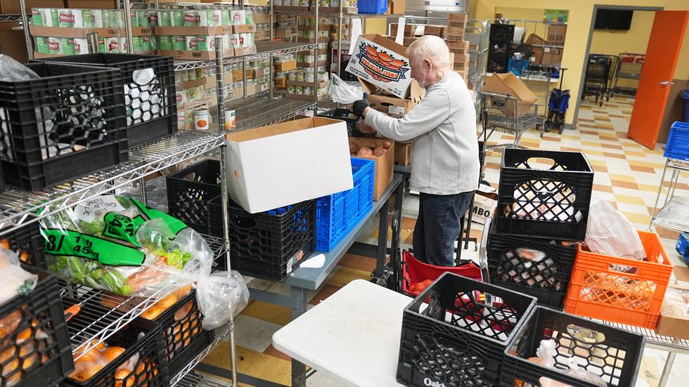 Volunteer Bruce Toben packs groceries durning an emergency food distribution at the at The...