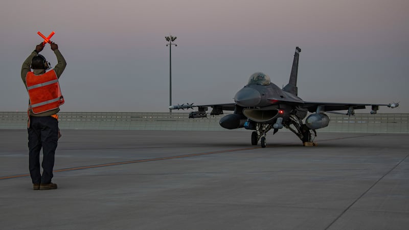 FILE - In this handout photo from the U.S. Air Force, an airman guides an F-16 Fighting Falcon...